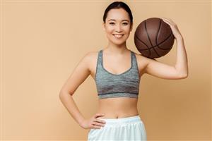 A Woman Holding A Basketball In Front Of A Neutral Background
