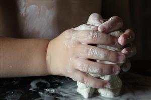 Young child's hands grasping modeling clay